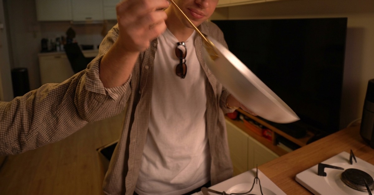 Suchy makaron spaghetti zanurzony w dużym garnku z wrzącą wodą.