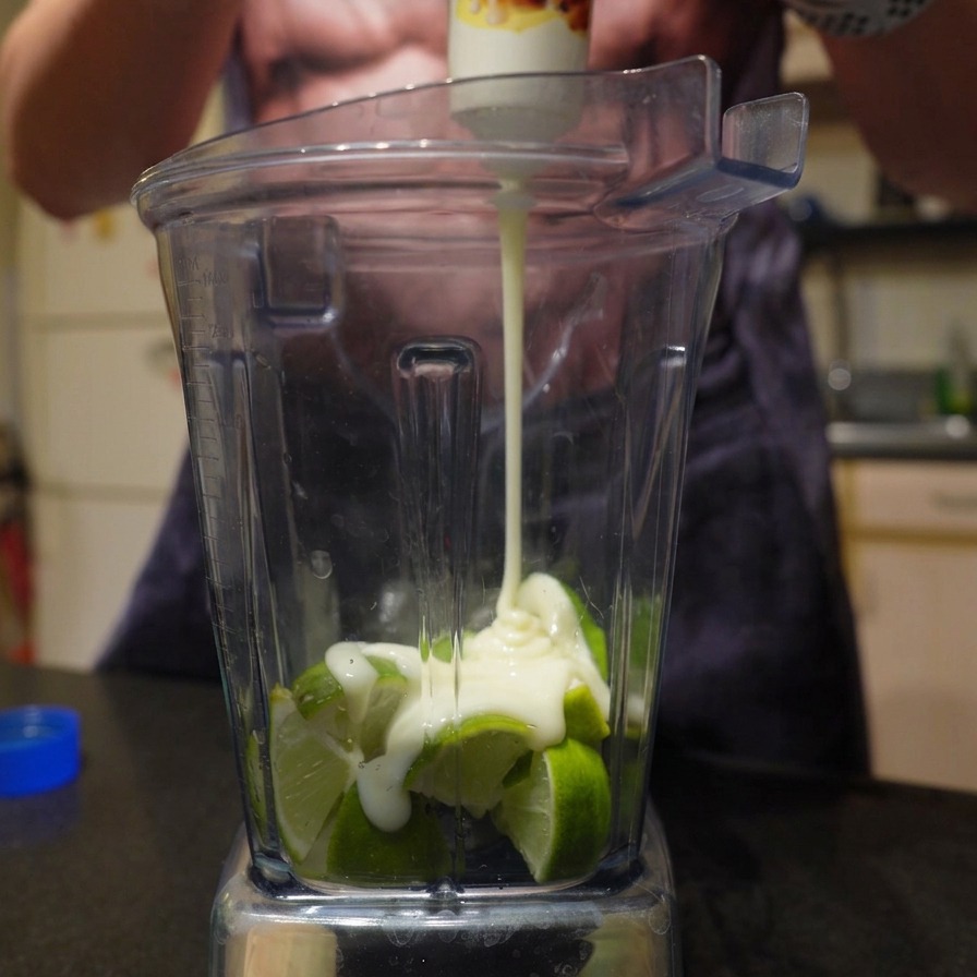 Wyciskanie gęstego, słodkiego mleka skondensowanego z tubki na limonki w blenderze.