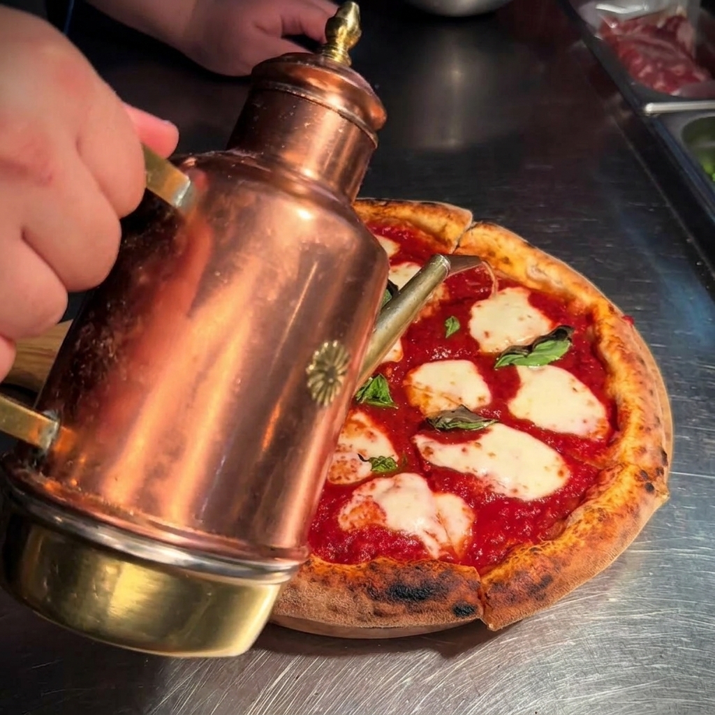Złocista oliwa lana z dekoracyjnego naczynia na świeżo pokrojoną pizzę margheritę.