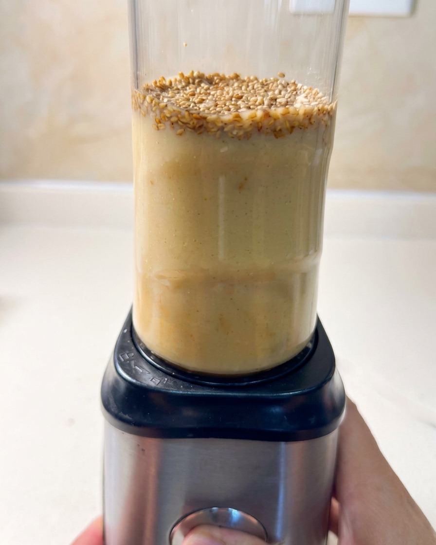 Mały blender kielichowy wypełniony składnikami na bulion do ramenu.