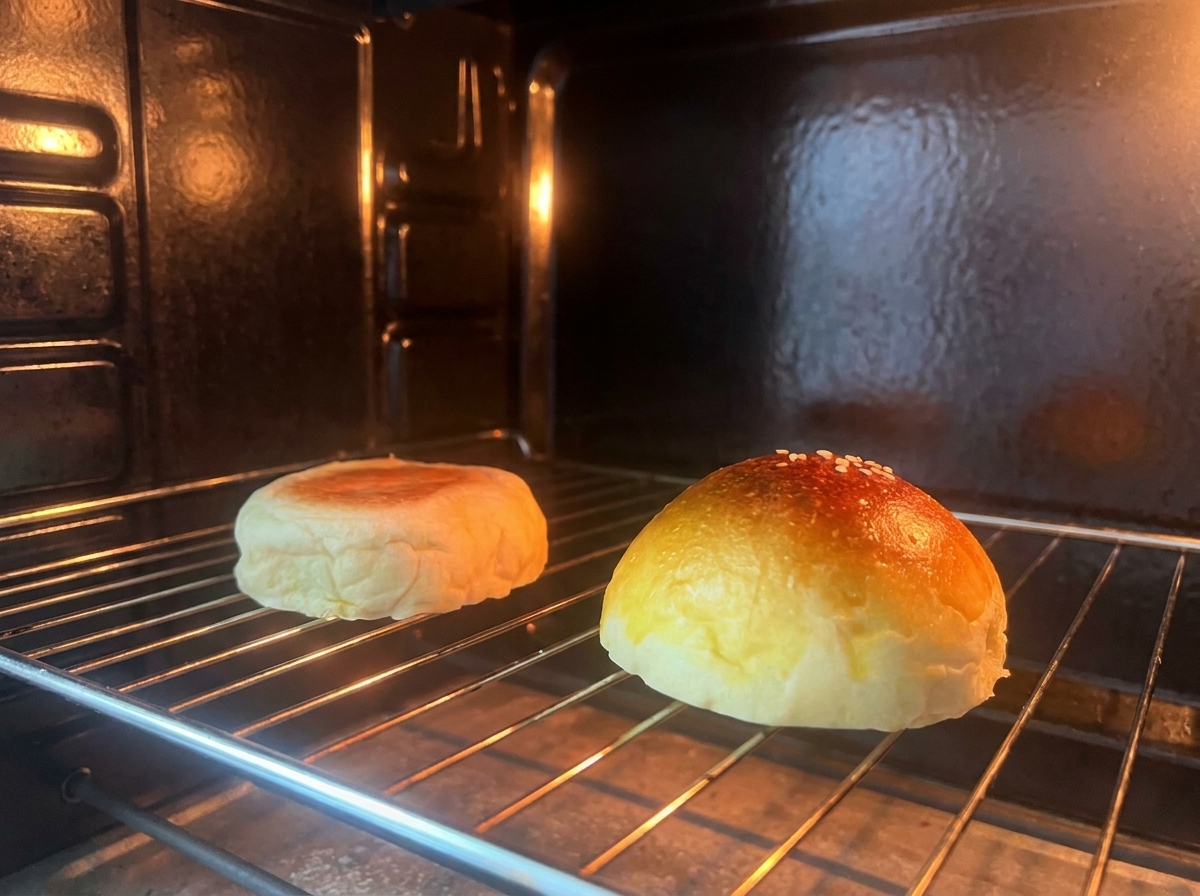 Dwie połówki bułki do burgera opiekające się na kratce wewnątrz piekarnika.
