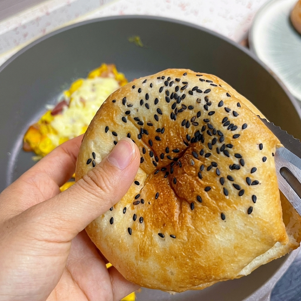Przypieczona bułka do burgera z czarnym sezamem w trakcie rozkrawania.