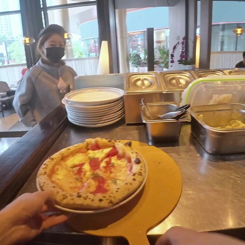 Świeże liście rukoli rozrzucone na wierzchu gorącej, bąbelkującej pizzy.