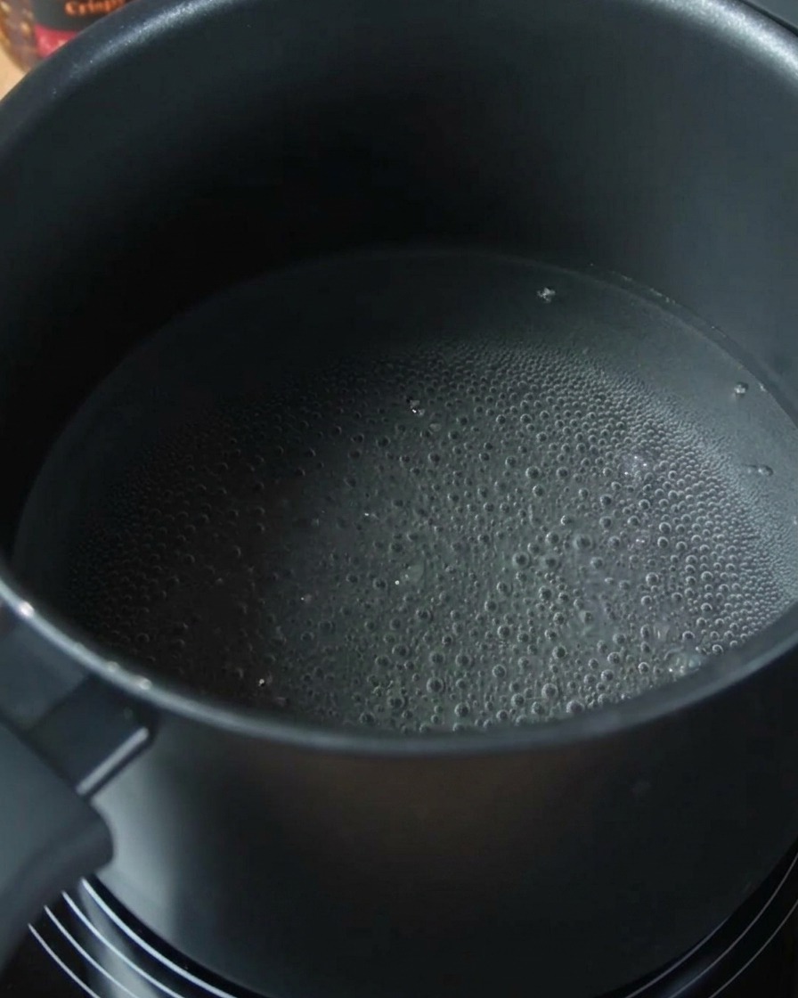 Makaron spaghetti gotujący się w garnku z wodą.