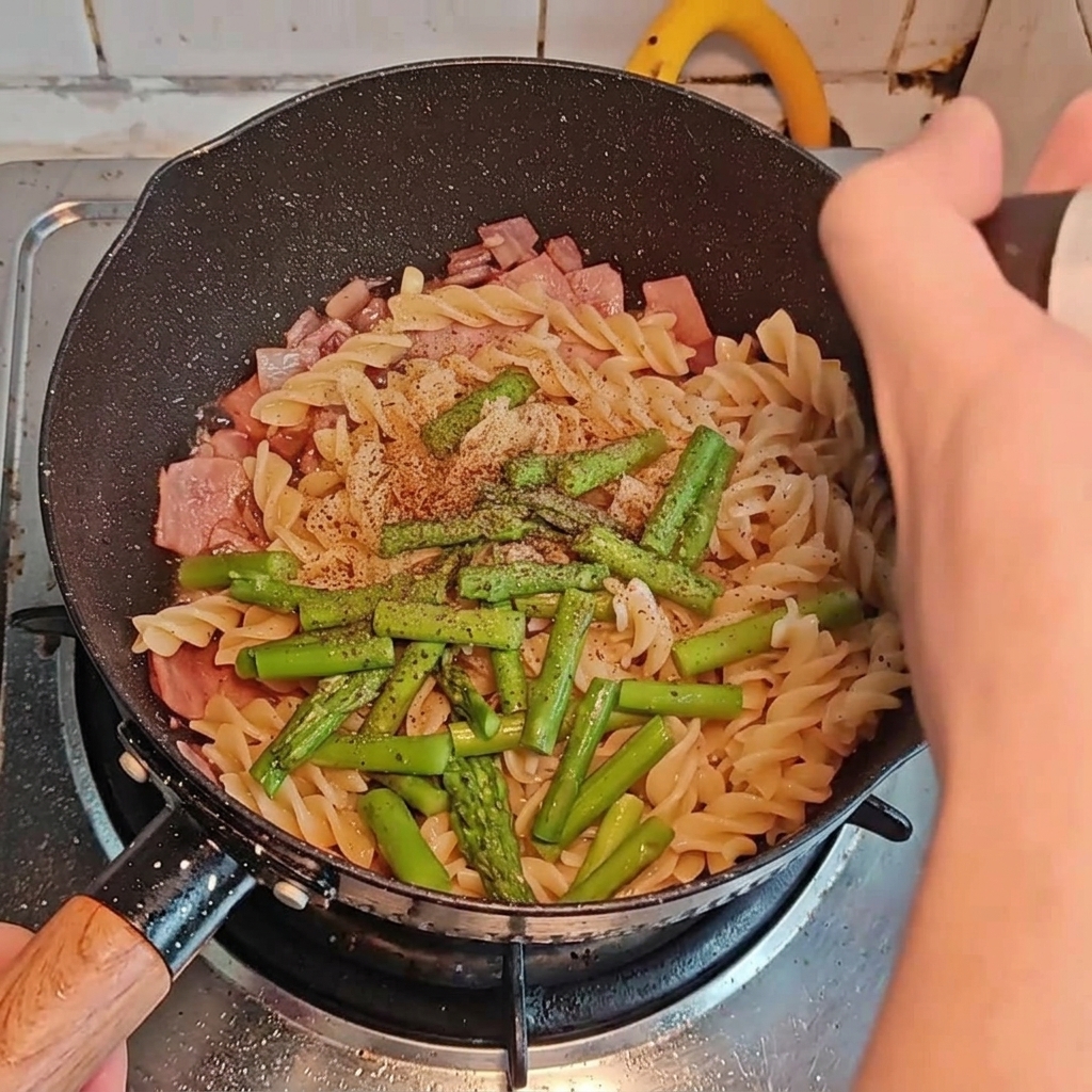 Przyprawy i sosy dodawane do makaronu z dodatkami na patelni.