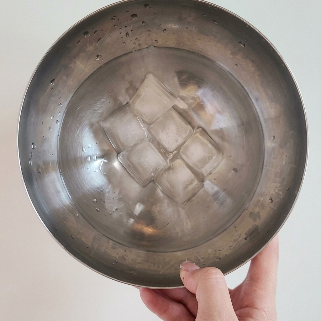 Makaron udon i grzyby enoki płukane w zimnej wodzie w celu ostudzenia przed podaniem.