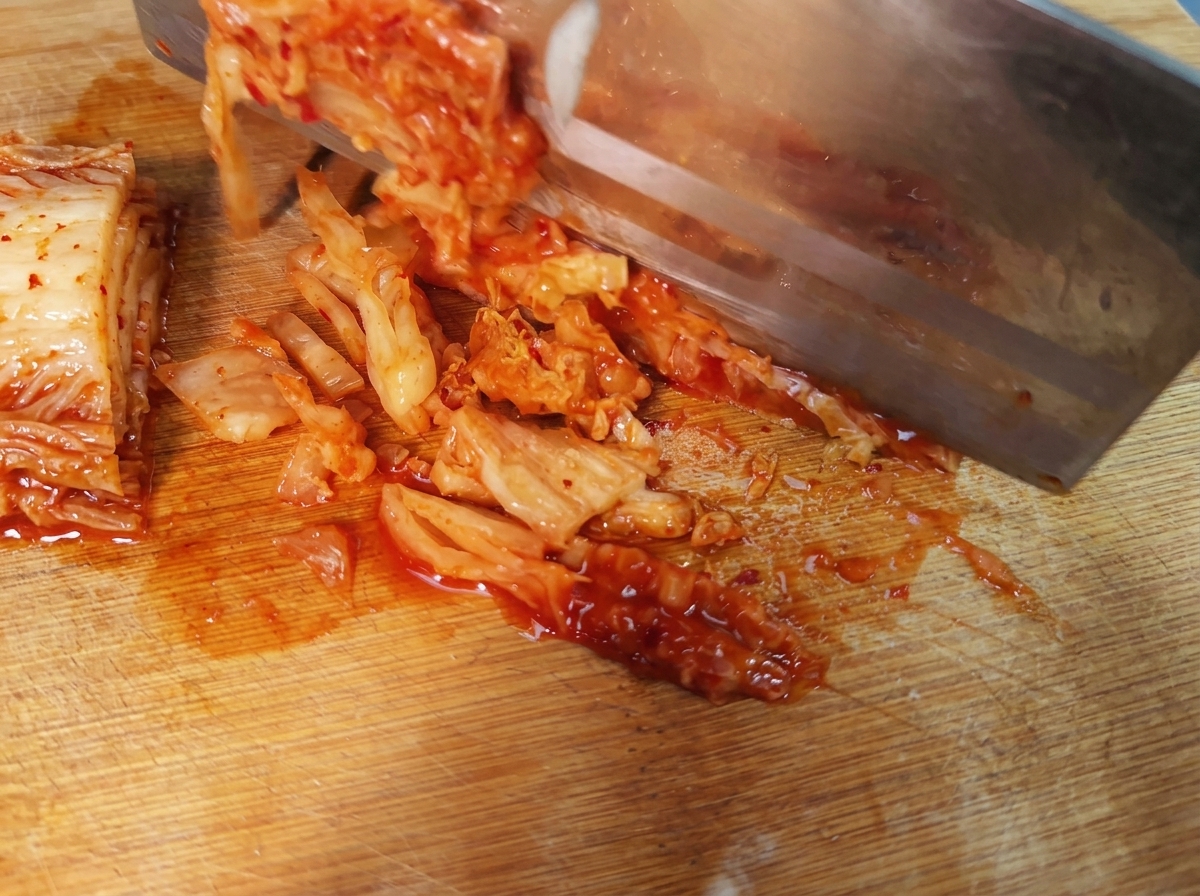 Kawałki pikantnego koreańskiego kimchi ułożone na desce do krojenia.
