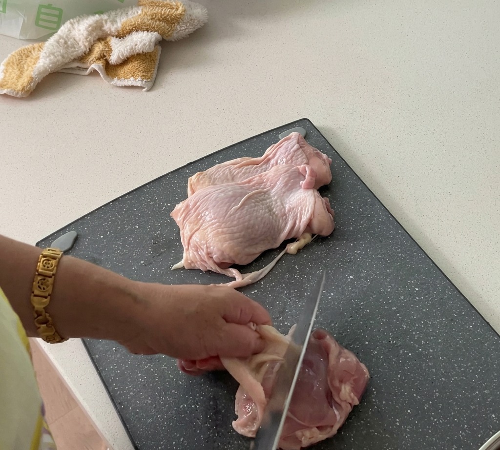Przygotowanie udek z kurczaka polegające na zdjęciu skóry i pokrojeniu mięsa w kostkę.