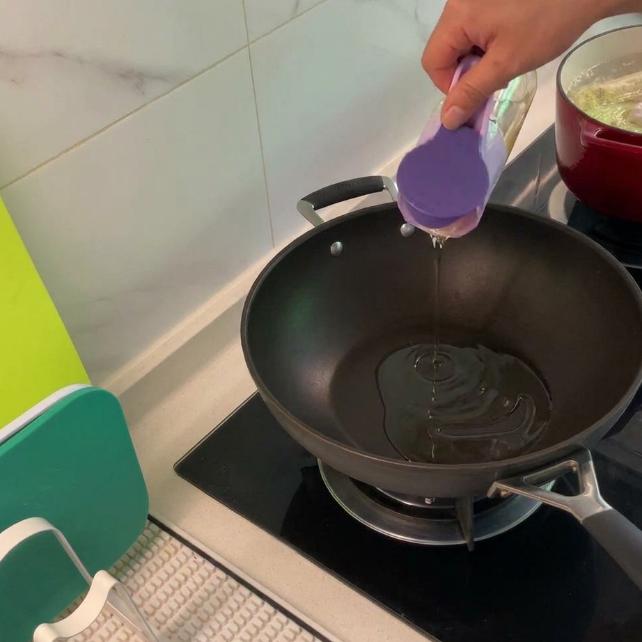 Pokrojony w kostkę kurczak i boczek smażące się razem na dużej patelni, w drodze do złotobrązowego koloru.