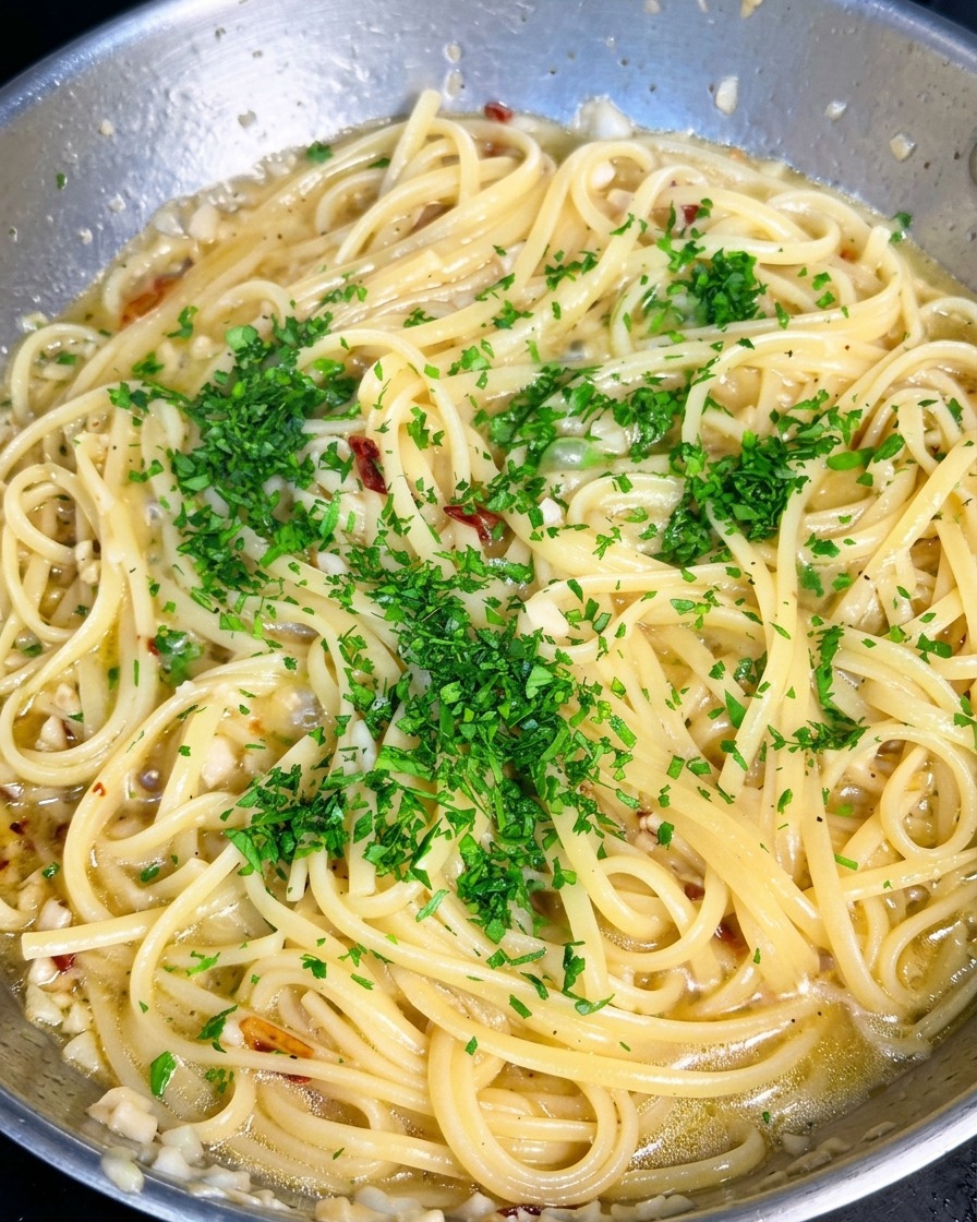 Świeża zielona posiekana pietruszka rozsypana na patelni z makaronem spaghetti.