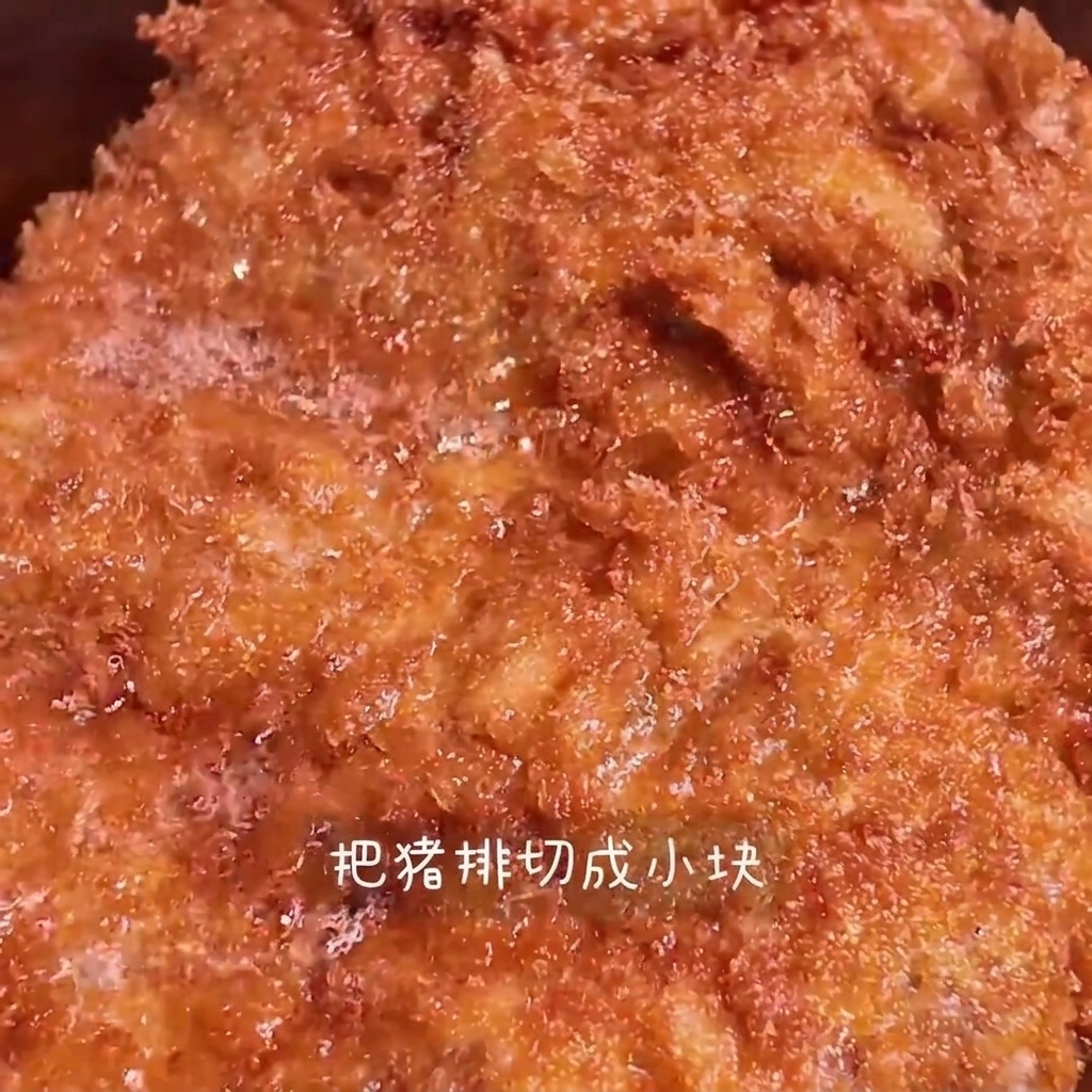 Chrupiący, złocisty kotlet krojony na paski na drewnianej desce.