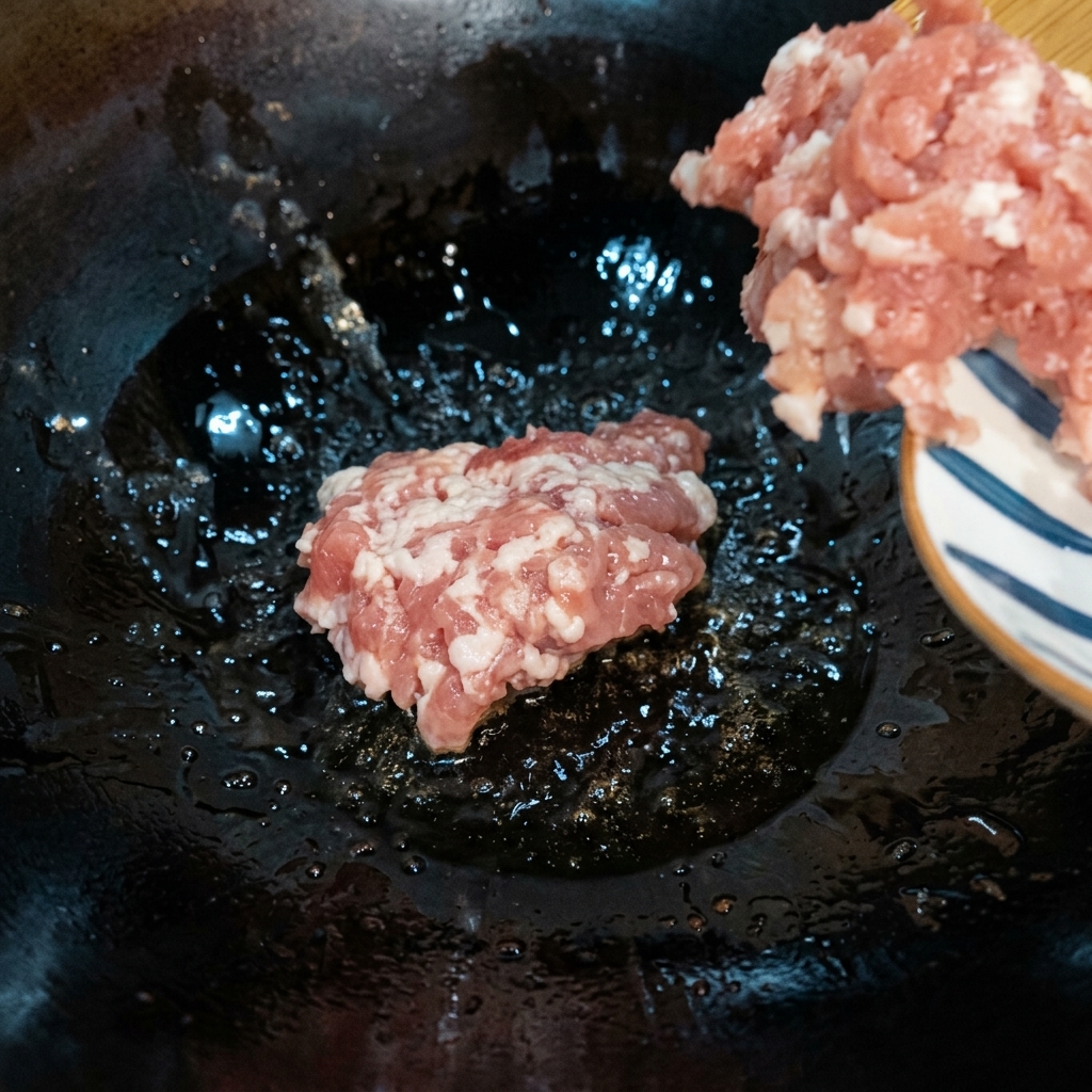 Mielone mięso smażone w gorącym woku na średnio-niskim ogniu do zarumienienia.