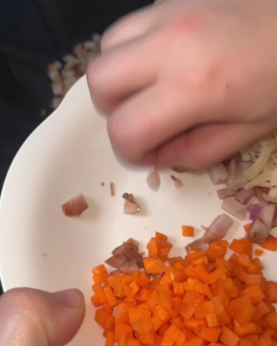 Smażenie stir-fry pokrojonej w kostkę wieprzowiny char siu i suszonych przegrzebków w wysezonowanym woku z roztopionym smalcem.