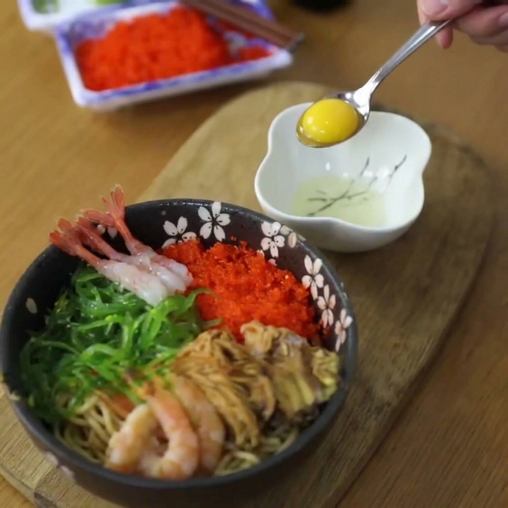 Surowe, wibrujące żółte żółtko jaja przepiórczego podnoszone małą metalową łyżką z białej miseczki.