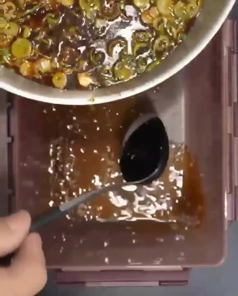 Surowe żeberka ułożone w pojemniku i zalewane aromatyczną marynatą.