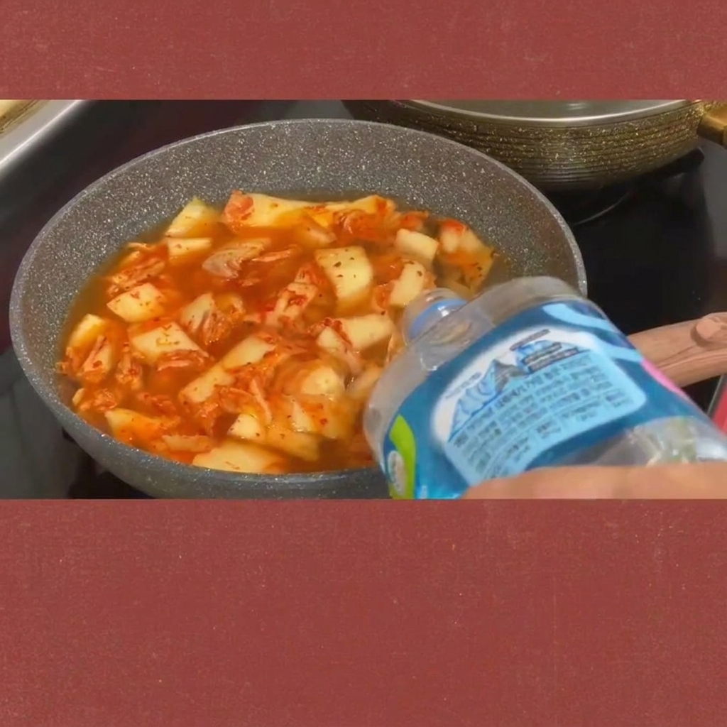 Plastry mielonki Spam dodawane do gotującej się zupy kimchi.