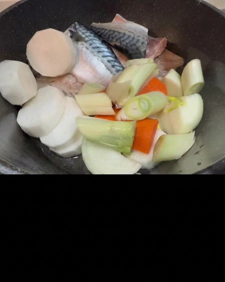 Kimchi dodawane do garnka z makrelą, rzodkwią i szczypiorkiem.