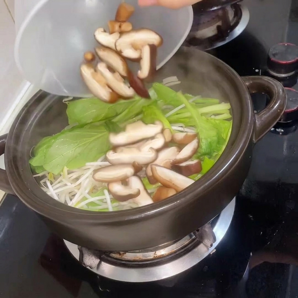 Pokrojone grzyby shiitake dodawane do garnka, a następnie zalewane gorącą wodą.