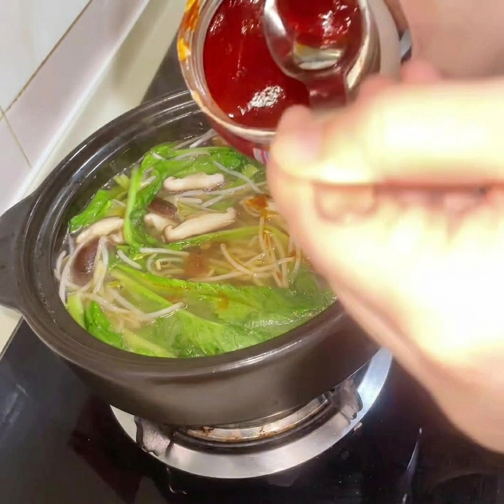 Koreańska pasta chili dodawana do gulaszu podczas mieszania.