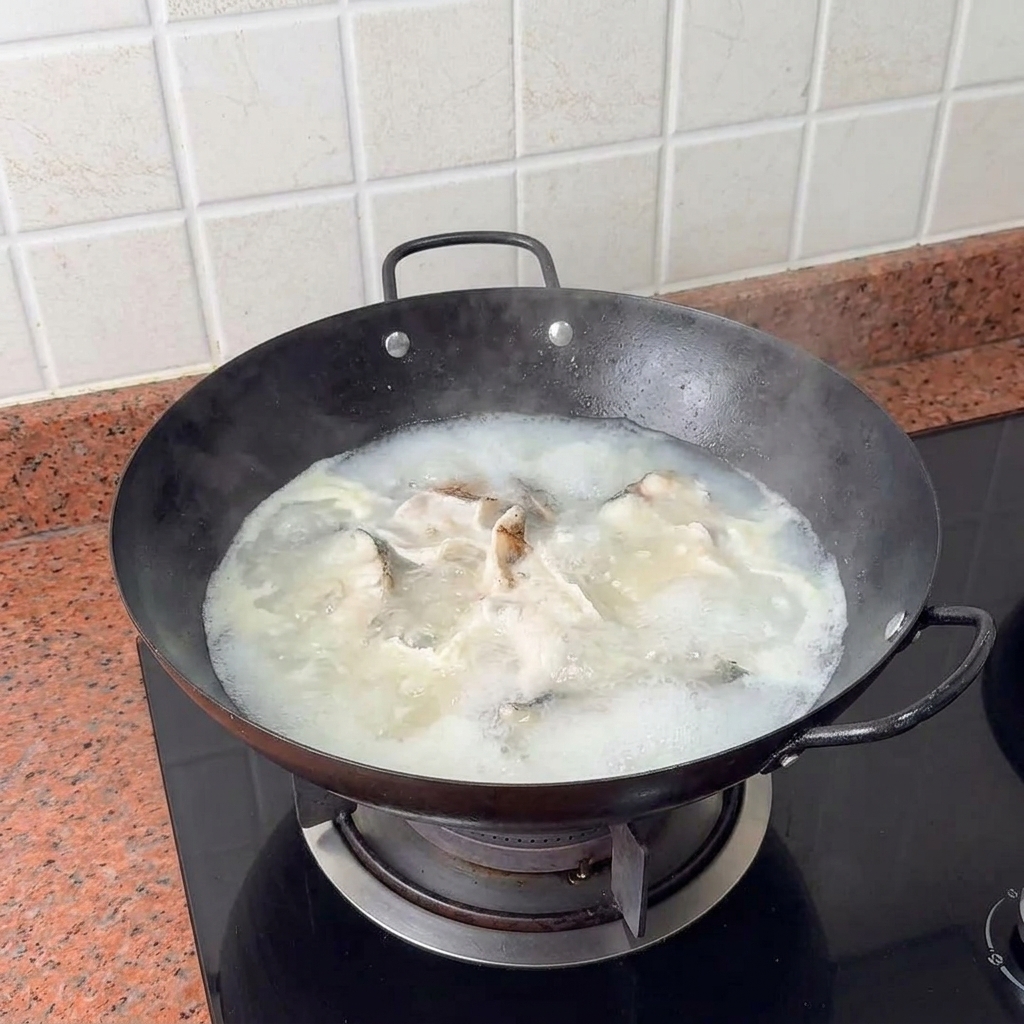 Kostki tofu delikatnie wkładane do gotującej się, kremowej zupy.