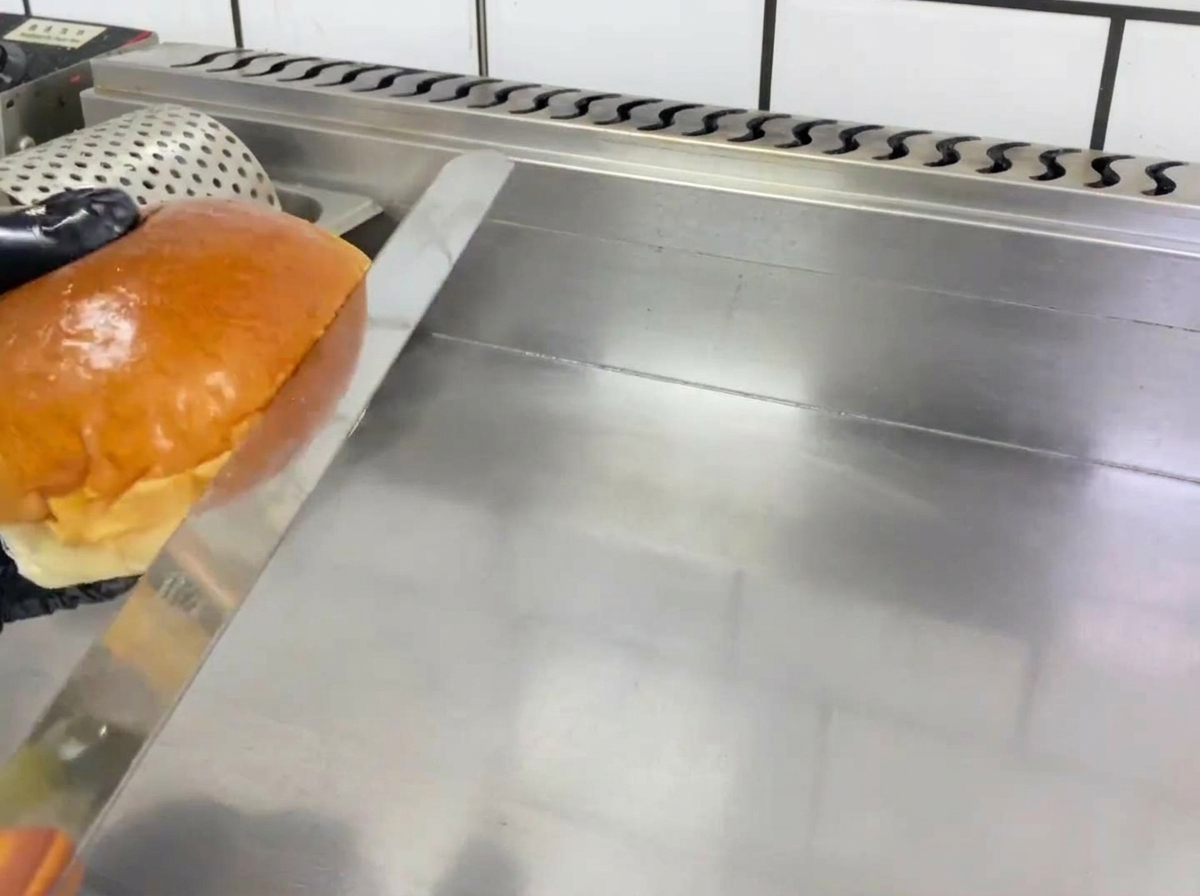 Połówki bułek do burgerów zrumienione na złoty kolor na patelni.