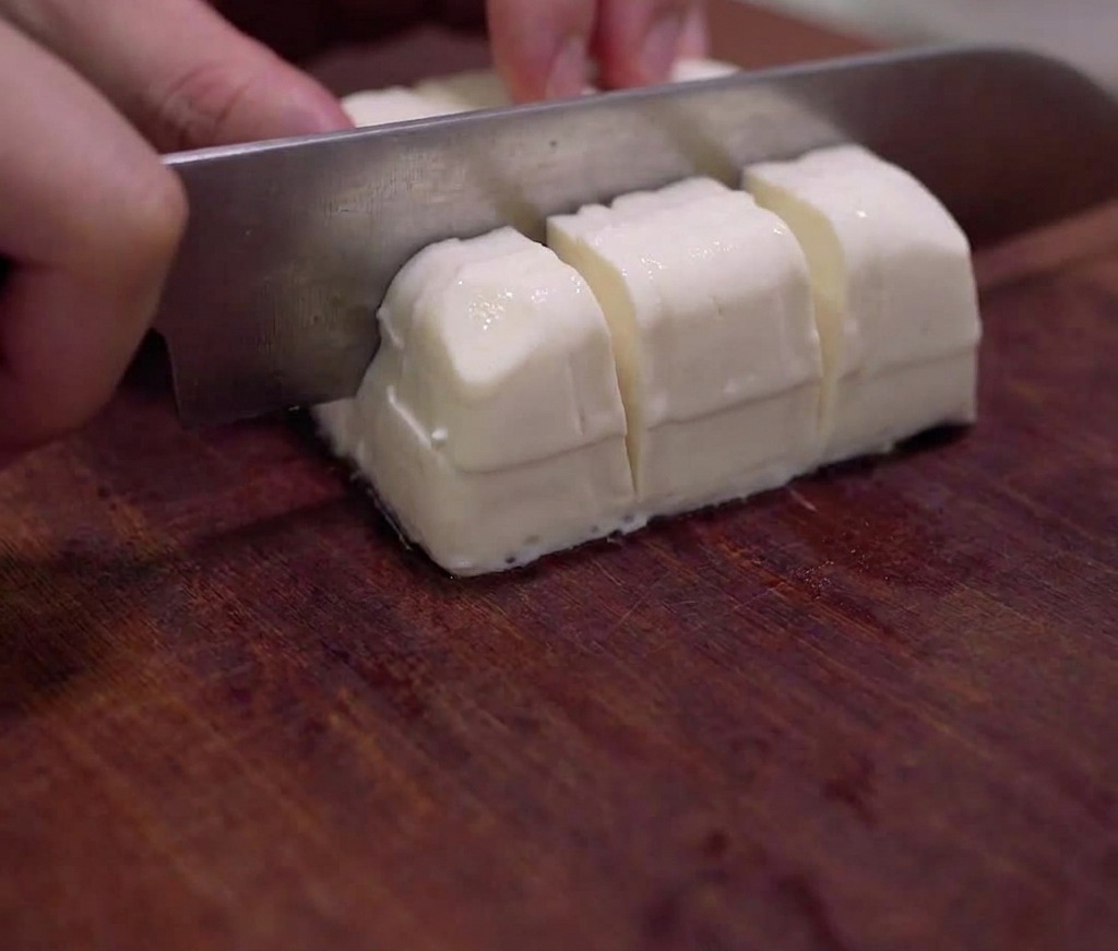 Blok jedwabistego tofu krojony w małą kostkę.