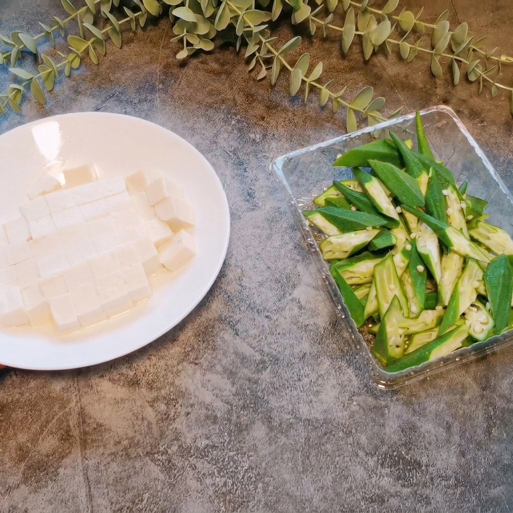 Kostka miękkiego tofu krojona na małe, równe części na talerzu.