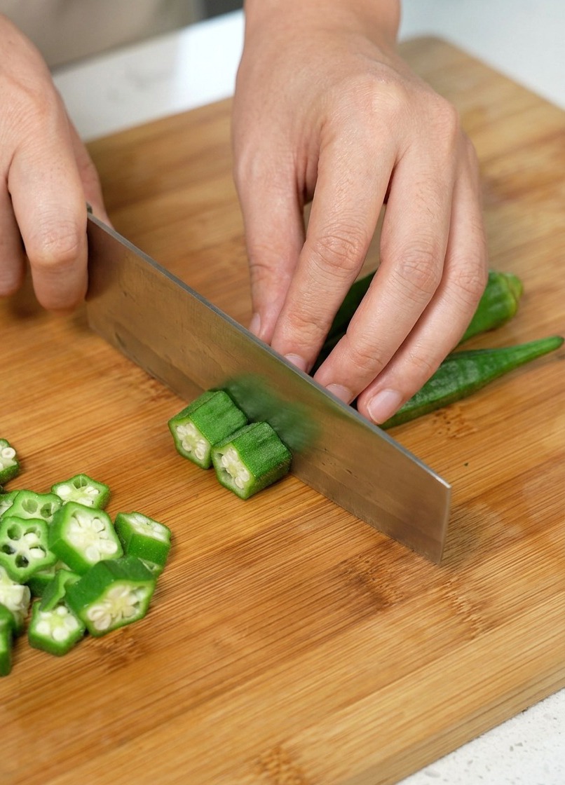 Okra krojona w plasterki na drewnianej desce do krojenia.