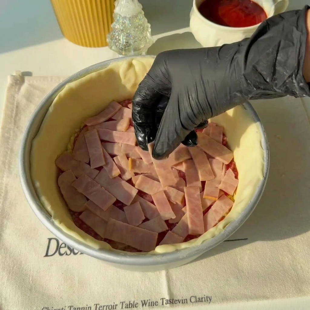 Paski boczku układane na warstwie salami w formie.