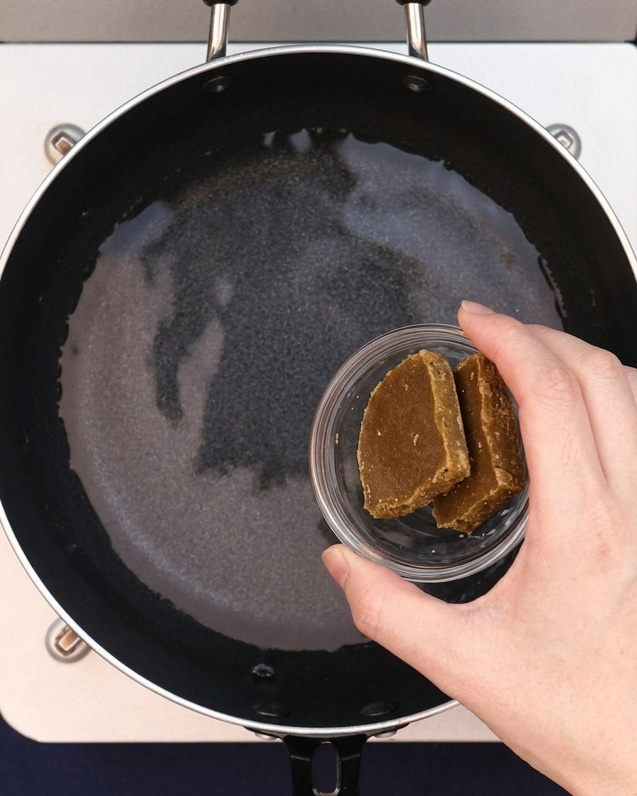 Dwie kostki pasty curry dodawane do wody w garnku.