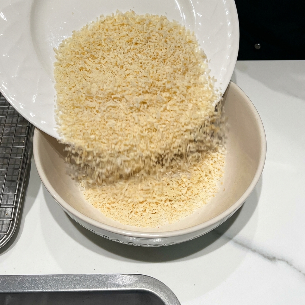 Miska z bułką tartą, startym parmezanem i przyprawami.