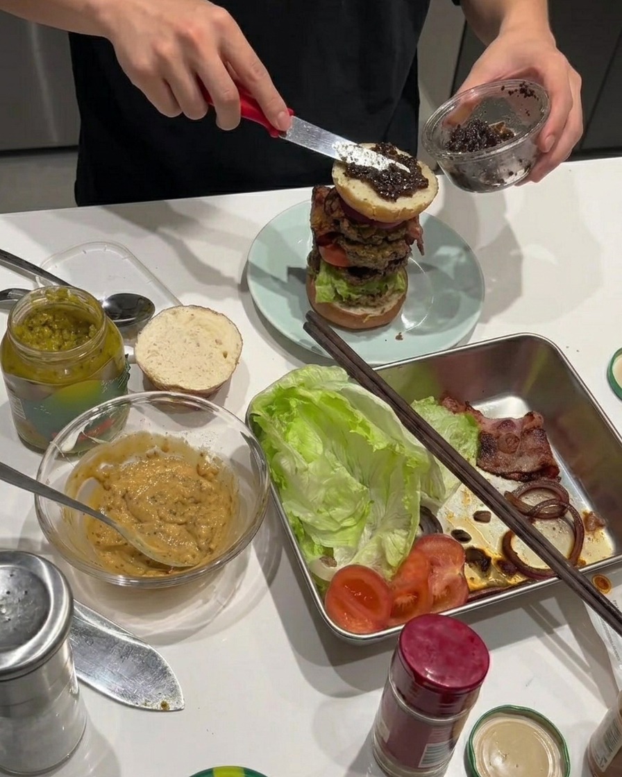 Pasta z czarnej trufli rozprowadzana na smażonych krążkach cebuli na burgerze.