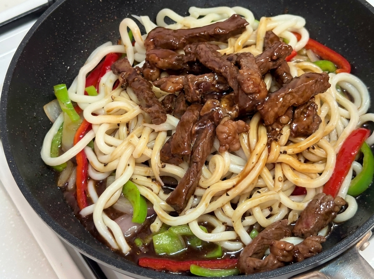Stir-fry mieszany szczypcami na patelni, aż pokryje się sosem.