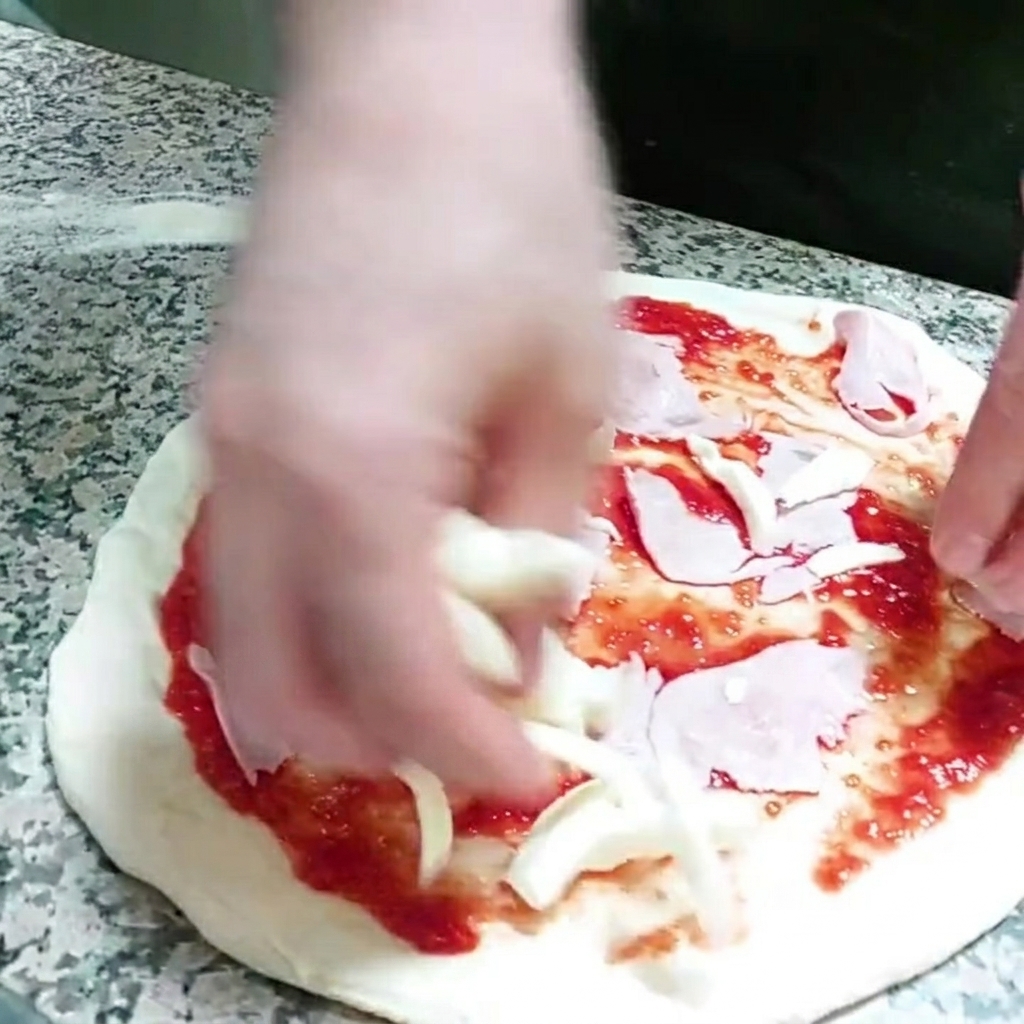 Kawałki sera mozzarella dodawane do pizzy.