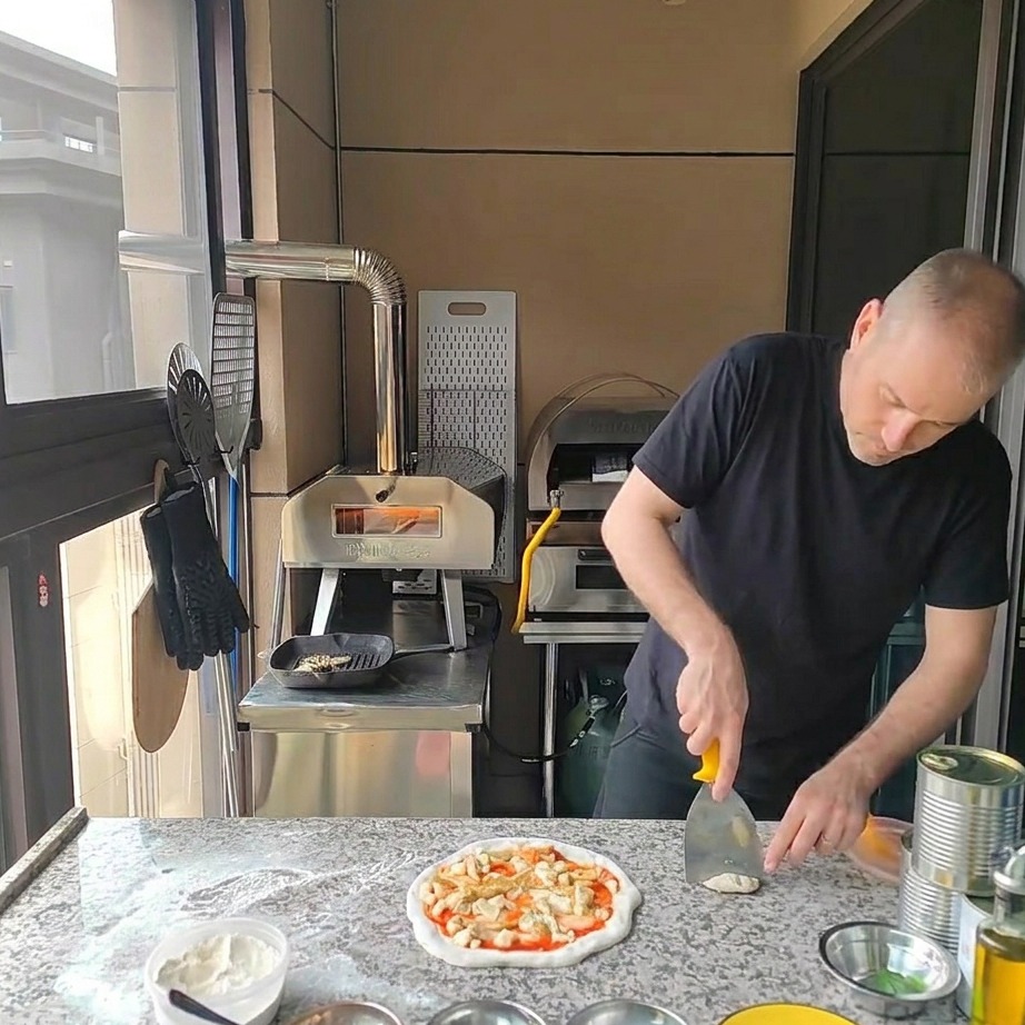 Kawałki grillowanego kurczaka układane na wierzchu pizzy z karczochami i serem.