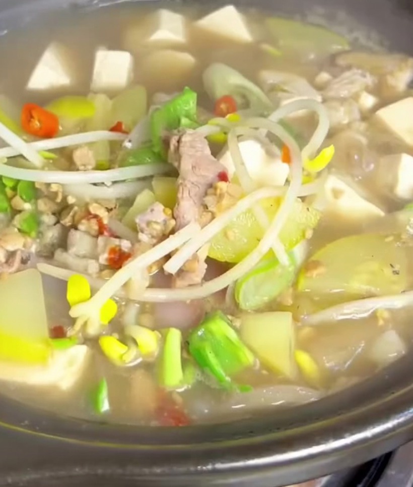 Twarde tofu pokrojone w idealną, małą kostkę na drewnianej desce do krojenia.