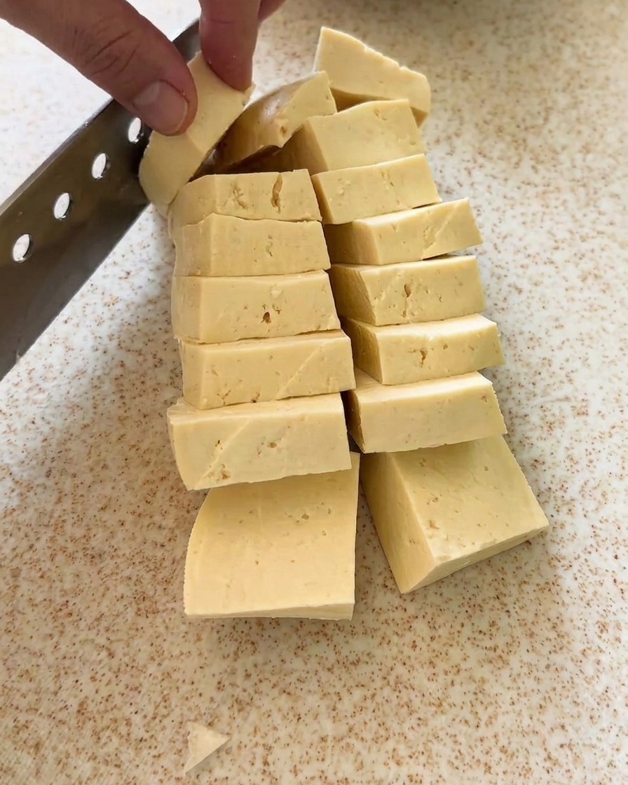 Kostka tofu krojona w równe, kształtne kawałki.