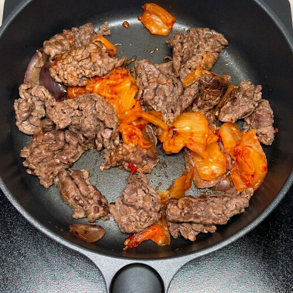 Koreańska pasta chili i proszek chili dodawane do patelni.