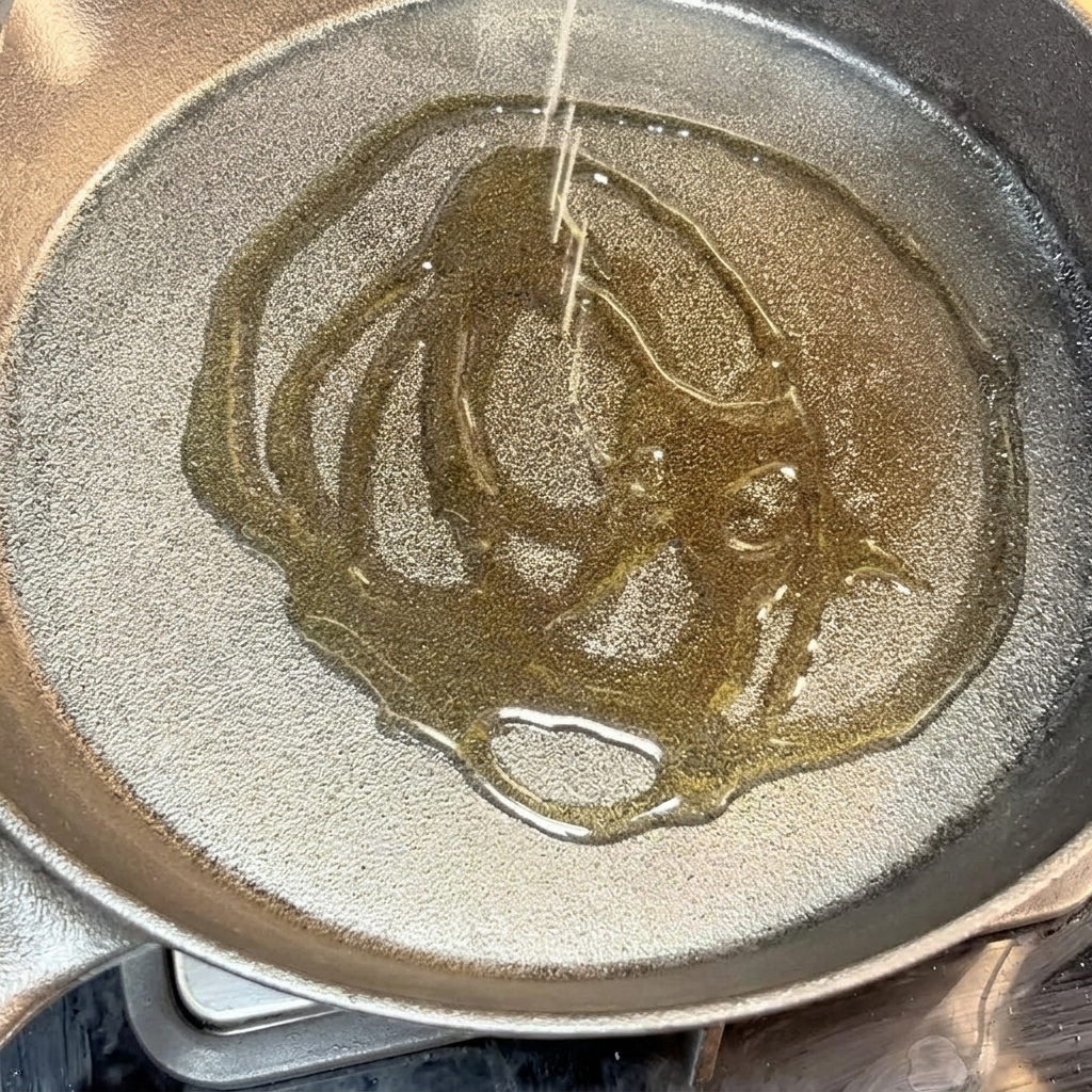 Doprawiony kotlet wołowy skwierczący na gorącej patelni żeliwnej.