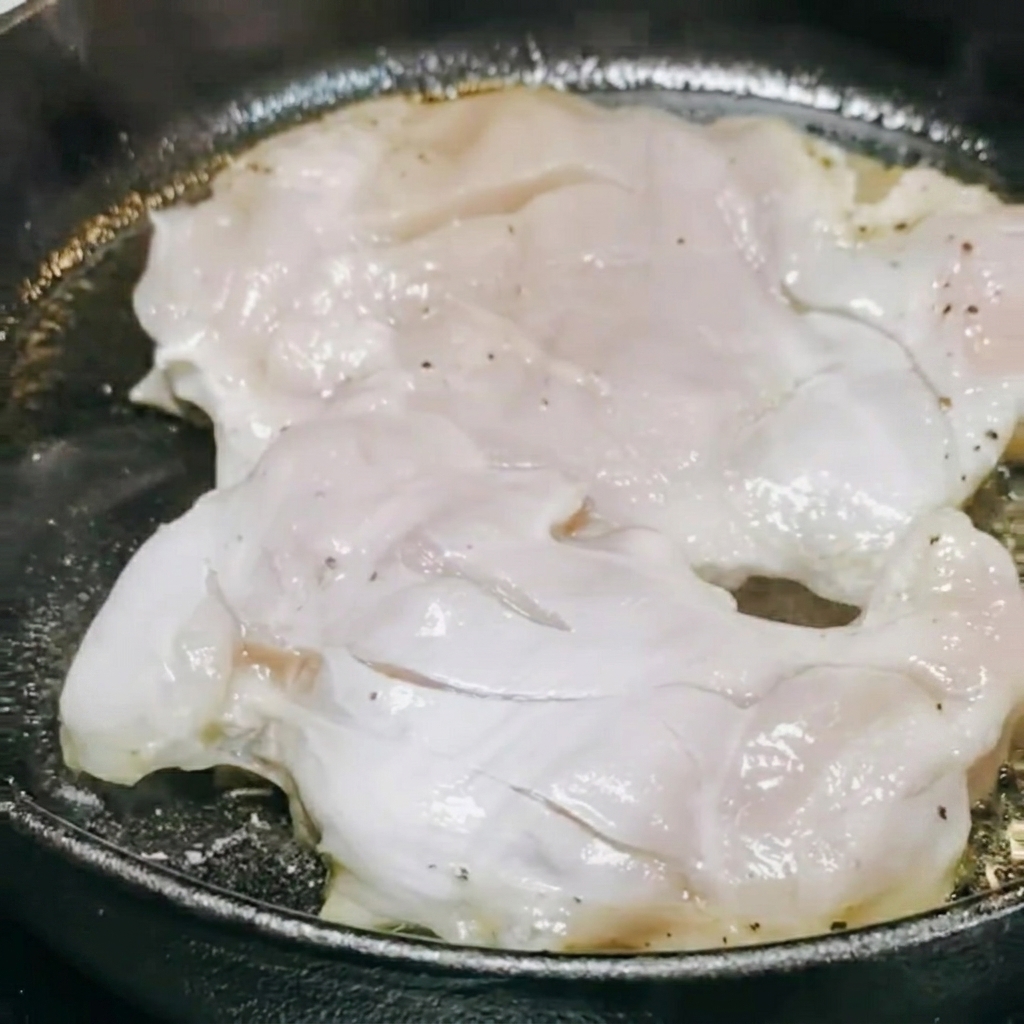 Sos teriyaki i białe wino wlewane na patelnię do smażącego się kurczaka.