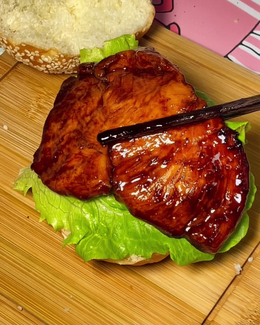 Kurczak teriyaki, pomidor i ser układane na bułce.