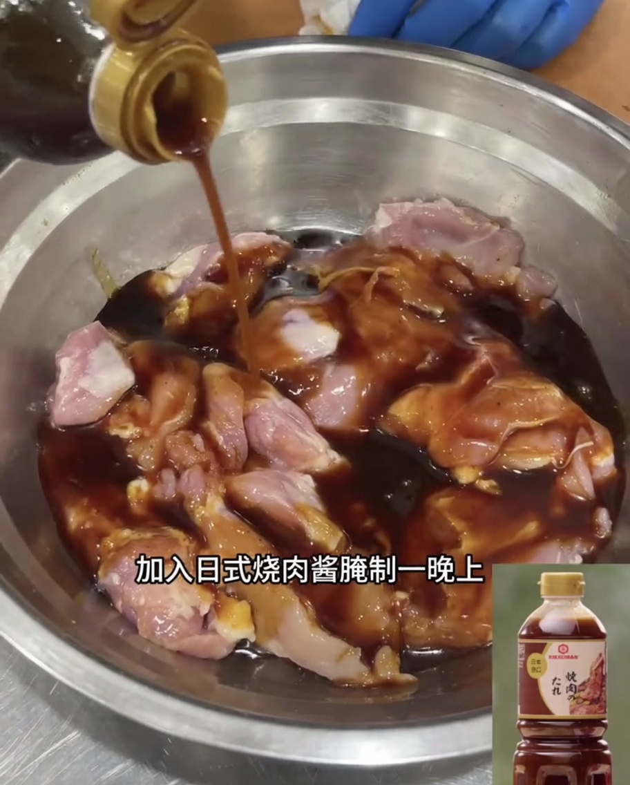 Udka z kurczaka bez kości moczące się w ciemnym japońskim sosie teriyaki w metalowej misce.