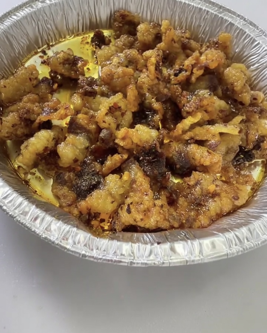 Chrupiące kawałki tłuszczu wołowego wymieszane z klasycznymi chipsami ziemniaczanymi na aluminiowej tacce.