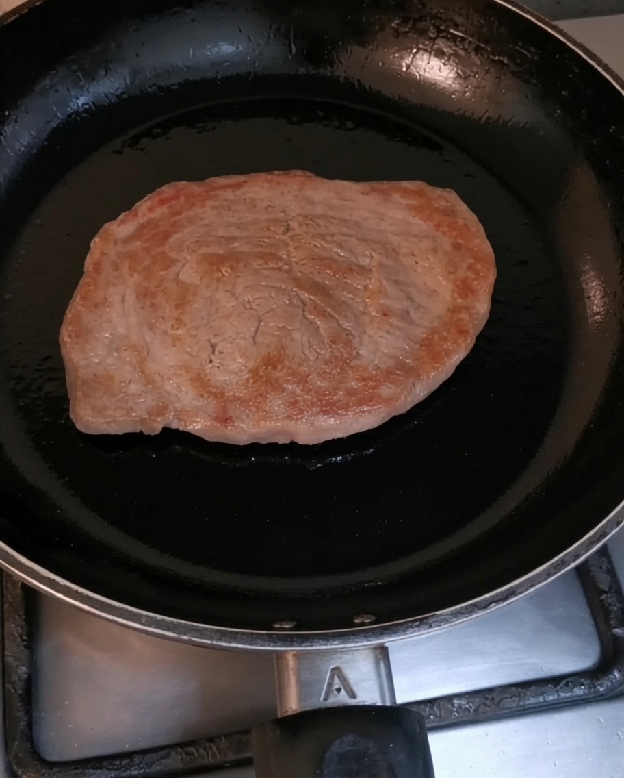 Polędwica wołowa przypiekająca się na gorącej czarnej patelni.