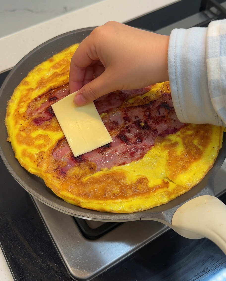 Dwa plastry żółtego sera położone na gorącym, usmażonym placku.