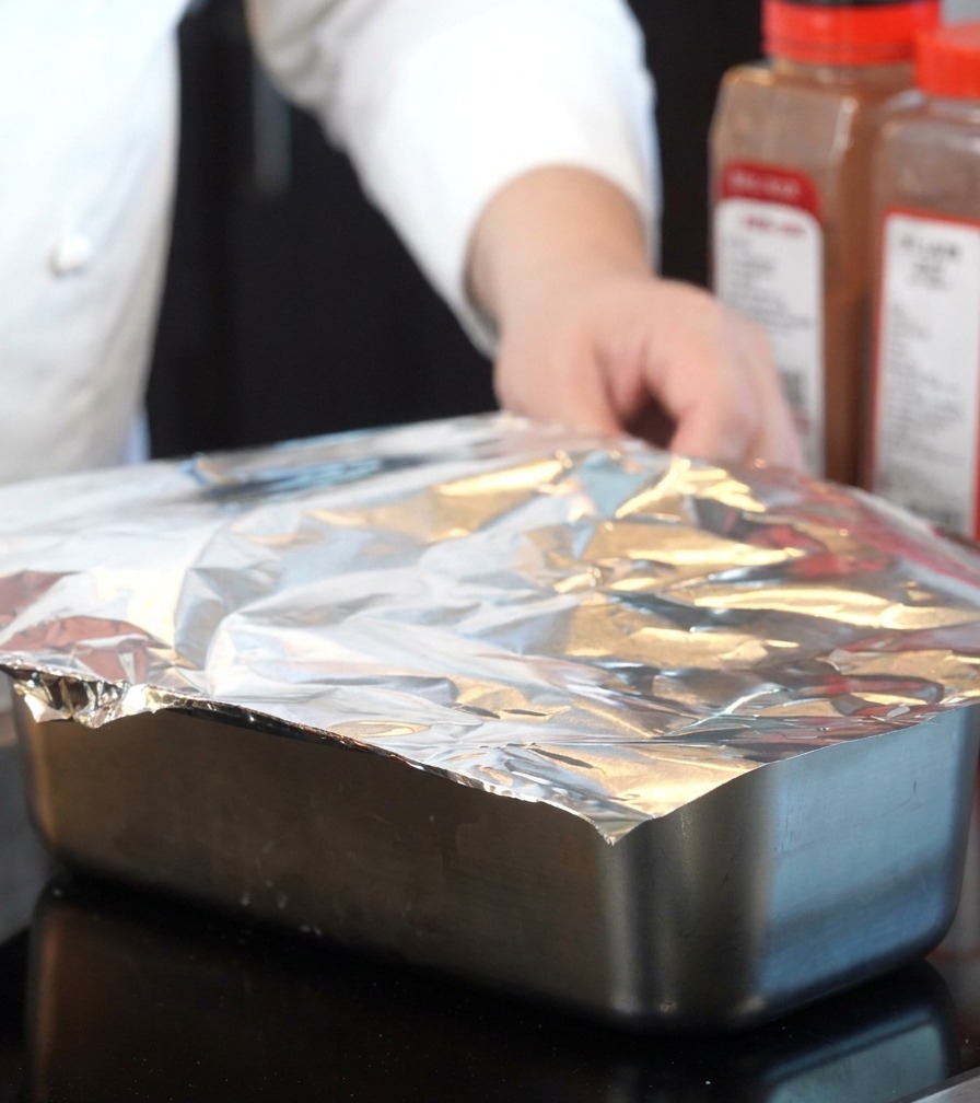 Naczynie do pieczenia szczelnie przykryte folią aluminiową.