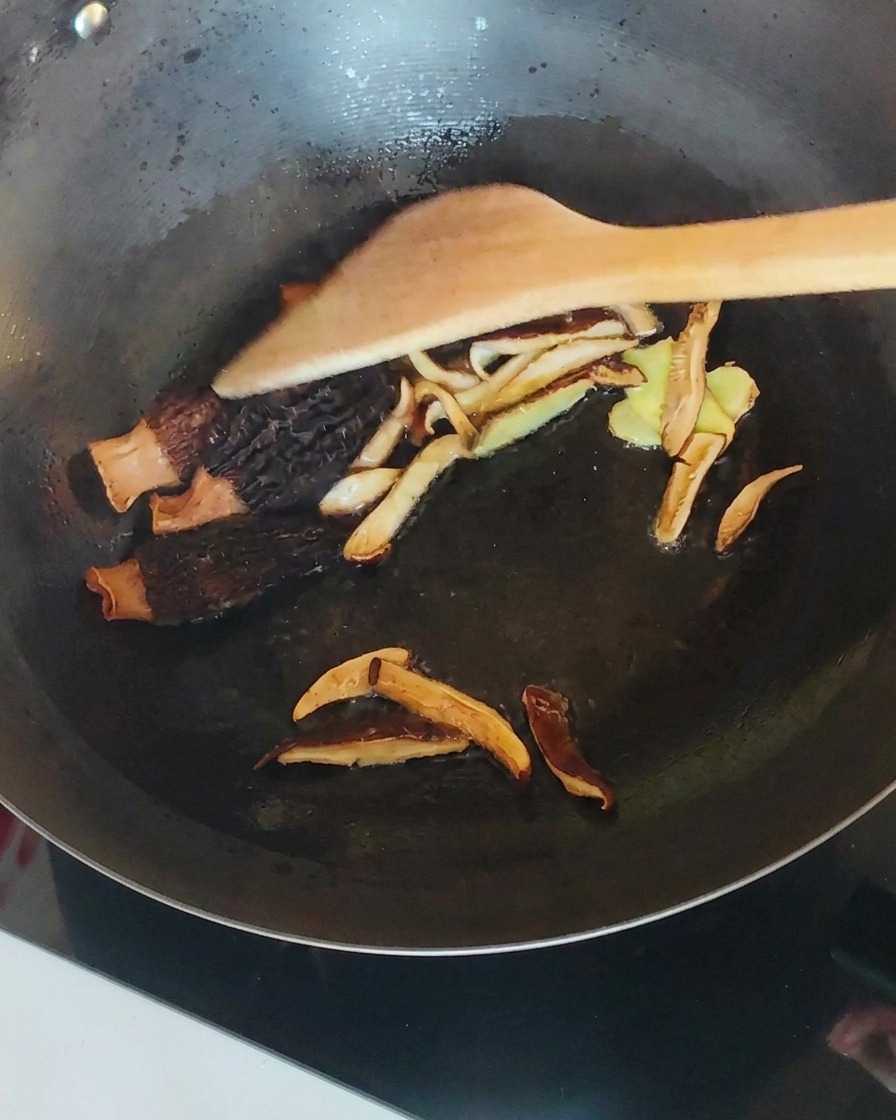 Szarpanego kurczaka wymieszany z grzybami i imbirem w woku.