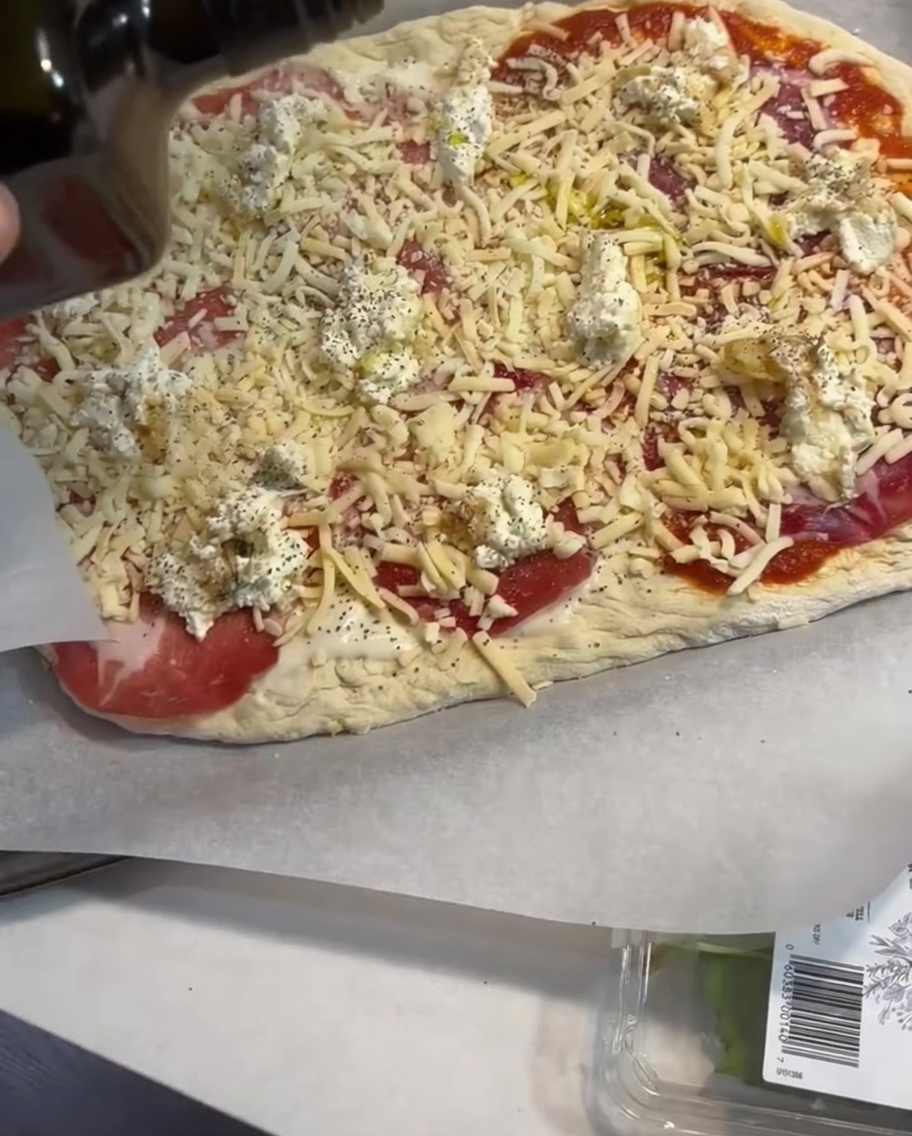 Cienka strużka oliwy z oliwek nakładana na gotową pizzę.