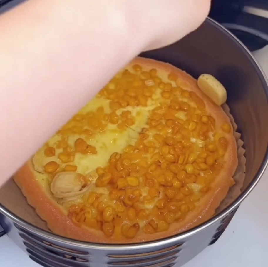 Smarowanie pędzelkiem brzegów częściowo upieczonej pizzy.