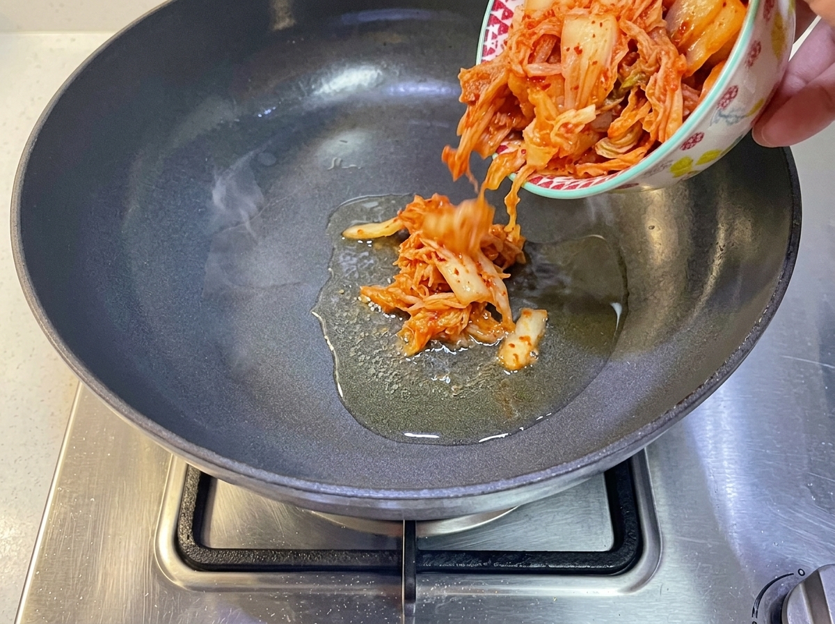 Koreańskie kimchi wrzucane na patelnię z rozgrzanym olejem.